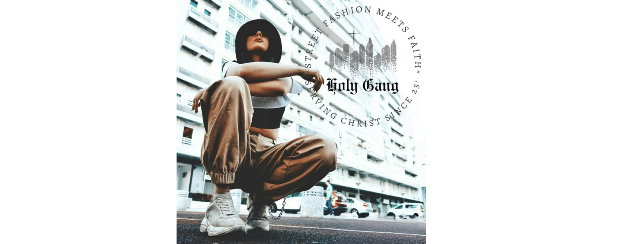 Urban streetwear model squatting in tan joggers and black crop top in front of city buildings, Holy Gang Christian streetwear logo overlayed with slogan "Street Fashion Meets Faith."