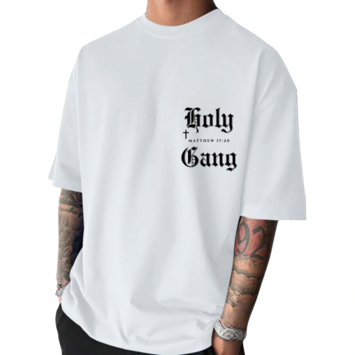 Front of male model wearing a white oversized Holy Gang t-shirt with black gothic logo, cross and Matthew 17:20 verse. 