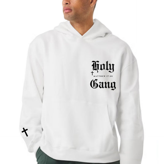 Front of male model. White Holy Gang hoodie with black gothic logo, cross on sleeve, and Matthew 17:20 verse.